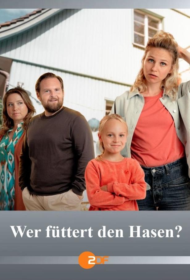 Eine Familie steht vor einem hellen Haus; im Vordergrund der Titel „Wer füttert den Hasen?“.