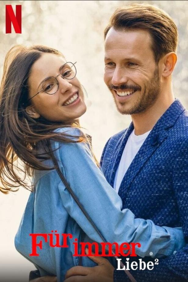 Ein lächelndes Paar umarmt sich; Werbung für den Film „Für immer Liebe 2“.