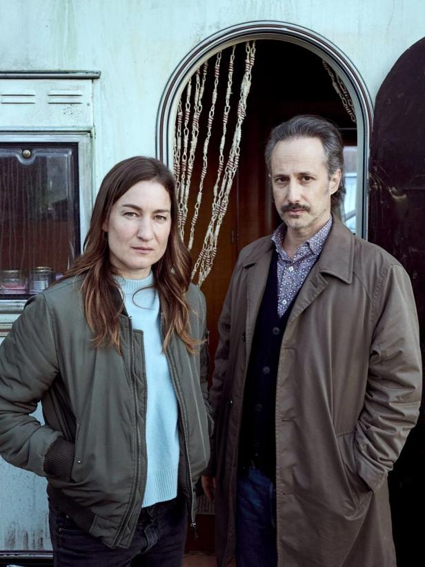 Eine Frau und ein Mann stehen vor einem Wohnwagen.