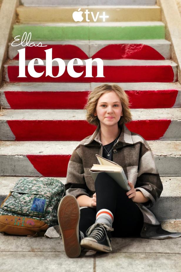Eine junge Frau sitzt mit einem Buch auf einer Treppe; Filmposter für „Ellas Leben“.