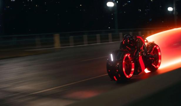 Tron-Motorrad zieht einen orangen Lichtschweif hinter sich her