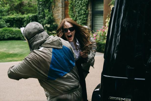 Frau wird vor Auto in Hausauffahrt von Mann in Schutzanzug angegriffen