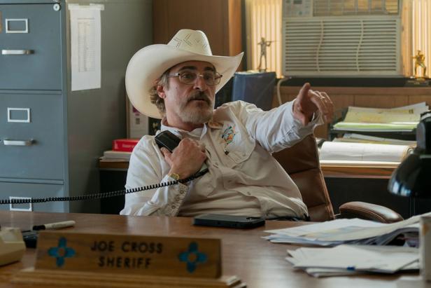 Joaquin Phoenix als Sheriff telefoniert gerade in seinem Büro am Festnetz