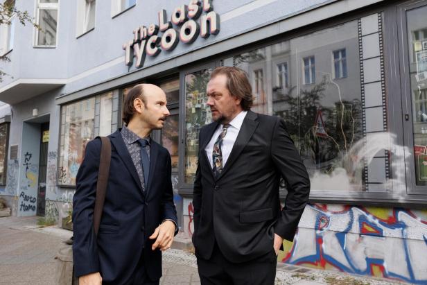 Leon Ullrich und Charly Hübner sprechen in Filmrollen auf der Straße miteinander