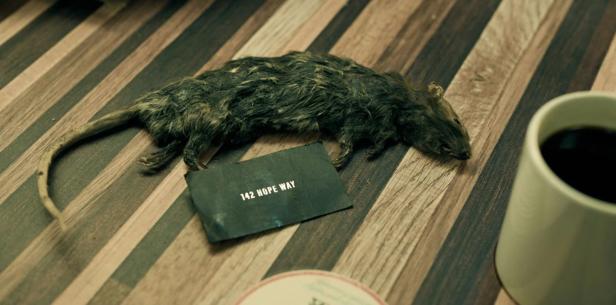 Tote Maus liegt auf einem Tisch neben einer Kaffeetasse