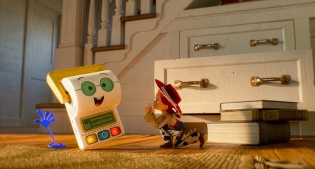Jessie aus Toy Story kniet vor dem sprechenden Spielzeug Smarty Pants auf einem Holzboden.
