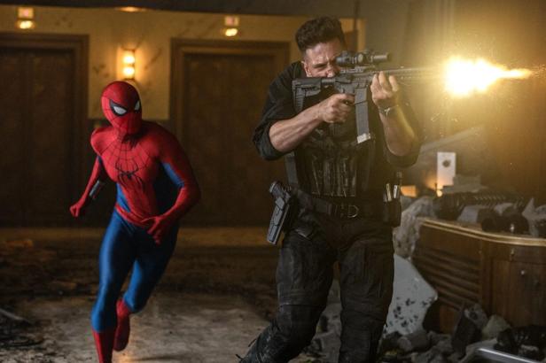 Spider-Man rennt neben dem Punisher her, der mit einem Gewehr schießt.