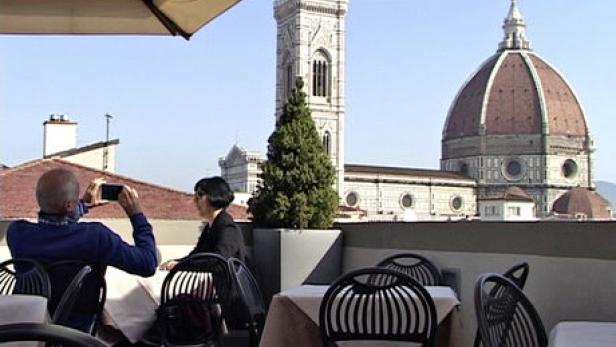 Ein Paar sitzt auf einer Dachterrasse in Florenz mit Blick auf den Dom.