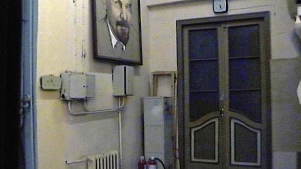 In einem Flur hängt ein Porträt von Lenin über einem Heizkörper.