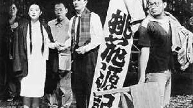 Eine Gruppe japanischer Demonstranten steht mit einem Banner in der Hand.