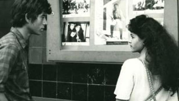 Ein junger Mann und eine junge Frau betrachten gemeinsam eine Fotogalerie.