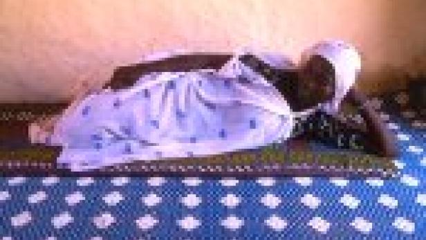 Eine ältere Frau liegt auf einer Matratze.