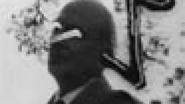 Ein Soldat mit Helm und Brille steht im Freien.