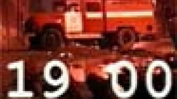 Ein rotes Feuerwehrauto steht vor einem dunklen Hintergrund, mit der Zahl 19:00 im Vordergrund.