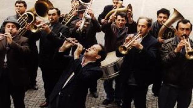 Eine Gruppe von Musikern spielt Blasinstrumente auf einem Platz.