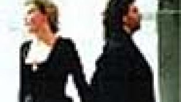 Eine Frau und ein Mann stehen Rücken an Rücken und schauen in unterschiedliche Richtungen.