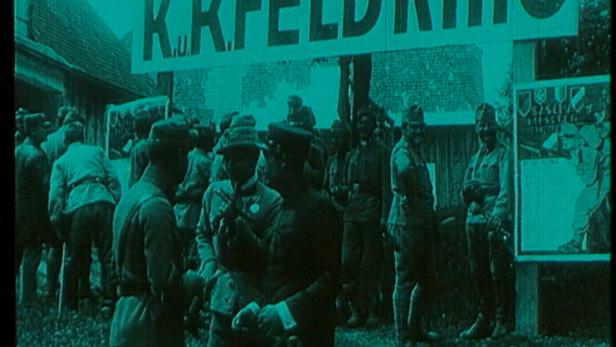 Soldaten stehen vor einem „K.K. Feldkino“-Schild.