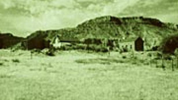 Eine historische Aufnahme einer Siedlung vor einem Tafelberg.