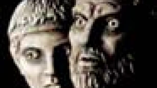 Zwei Statuen, eine mit einem jungen und eine mit einem älteren, bärtigen Gesicht.