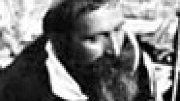 Ein Mann mit Bart und Kippa blickt zur Seite.