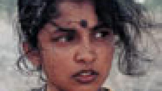 Ein junges Mädchen mit dunklen Haaren und einem Bindi auf der Stirn blickt in die Ferne.