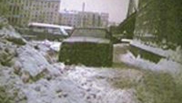Ein Auto fährt durch eine verschneite Straße in einer Stadt.