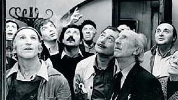 Eine Gruppe von Menschen blickt erwartungsvoll nach oben.