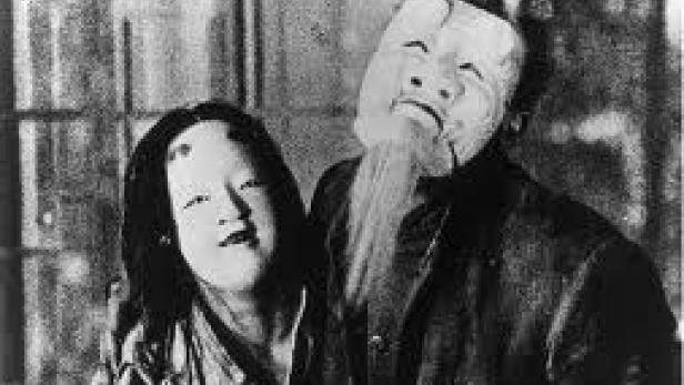 Zwei Personen tragen traditionelle japanische Masken.