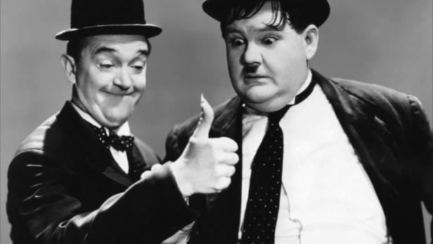 Stan Laurel und Oliver Hardy, bekannt als Laurel und Hardy, geben beide einen Daumen hoch.