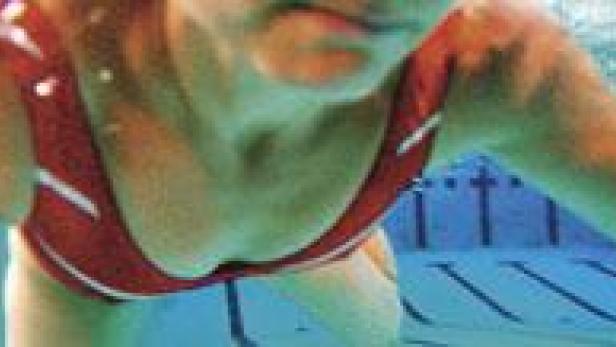 Eine Frau schwimmt in einem Schwimmbad unter Wasser.