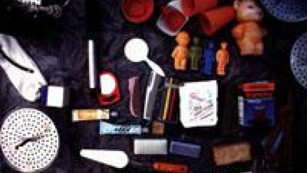 Verschiedene Alltagsgegenstände sind auf einer dunklen Oberfläche angeordnet.