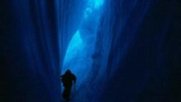 Eine Person geht durch eine eisige Schlucht in der Antarktis.