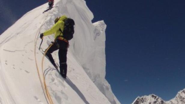 Ein Filmposter für „Kunyang Chhish East: First Ascent“ mit Bergsteigern in einer verschneiten Berglandschaft.