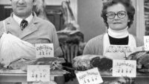 Ein Metzger und eine Metzgerin stehen hinter einer Theke mit Fleischprodukten.