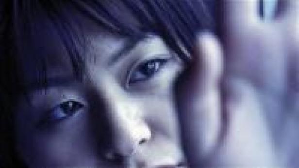 Nahaufnahme eines jungen asiatischen Gesichts mit dunklen Augen.