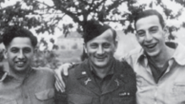 Drei Männer stehen im Freien und lächeln in die Kamera.