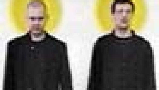 Zwei Männer in schwarzen Hemden stehen nebeneinander vor einem weißen Hintergrund mit gelben Kreisen hinter ihren Köpfen.