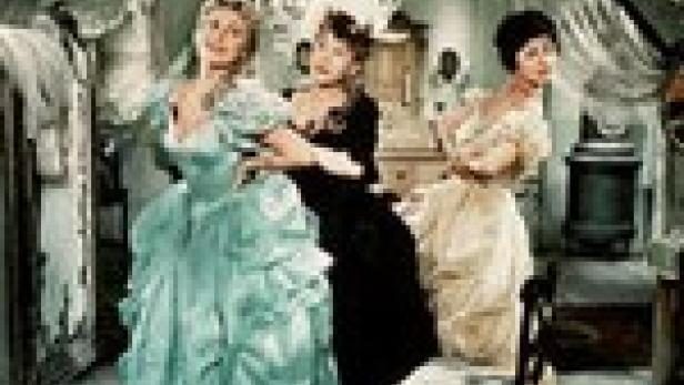 Drei Frauen in historischen Kleidern posieren in einem opulenten Raum.