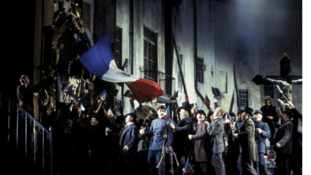 Eine Menschenmenge schwenkt französische Flaggen vor einem Gebäude.