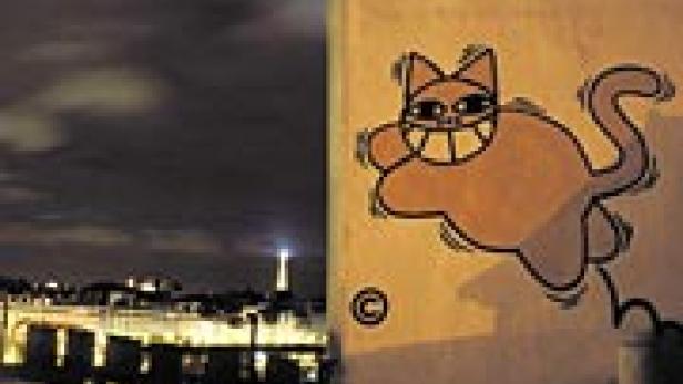 Ein Graffiti einer grinsenden Katze an einer Wand, im Hintergrund die Skyline von Paris bei Nacht.