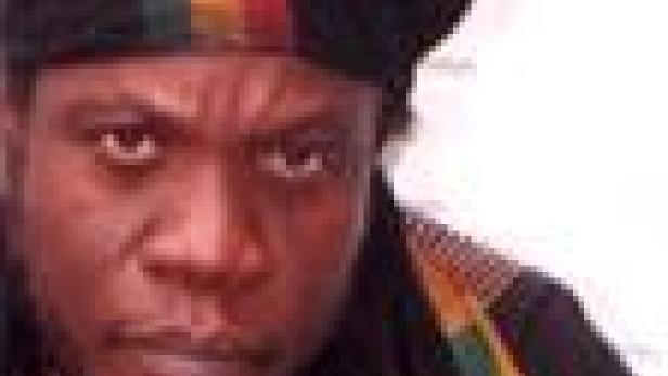 Ein Mann mit einer Rasta-Mütze blickt ernst in die Kamera.