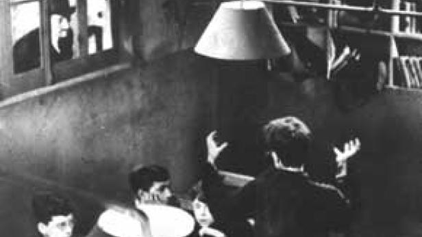 Szene aus dem Film „Das Cabinet des Dr. Caligari“ mit drei Personen in einem Raum.