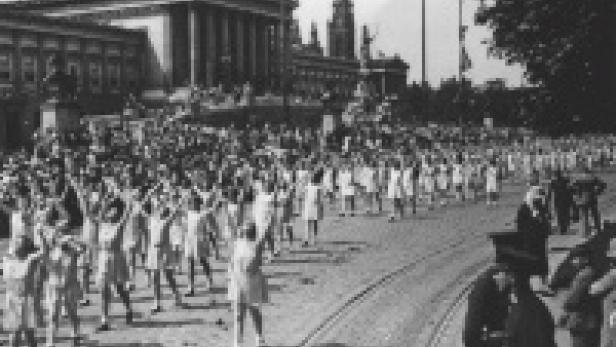 Eine große Gruppe von Menschen marschiert vor dem österreichischen Parlament in Wien.