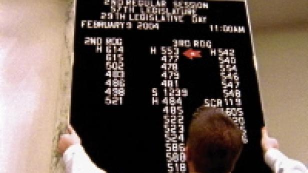 Eine Person betrachtet eine Tafel mit dem Vermerk „2nd Regular Session“.