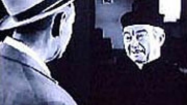 Ein Mann mit Hut spricht mit einem Priester.