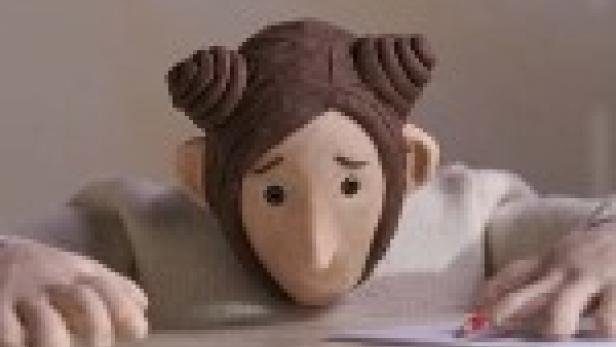 Eine Knetfiguren-Frau sitzt an einem Tisch und schreibt einen Brief.