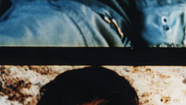 Nahaufnahme des Gesichts einer Person unter einem blauen Stoff.