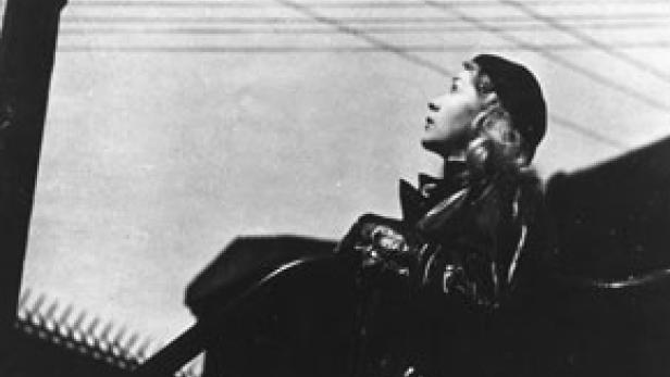 Eine Frau mit Hut blickt in den Himmel.