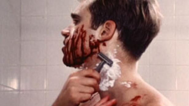 Ein Mann rasiert sich, sein Gesicht und Hals sind mit Blut bedeckt.