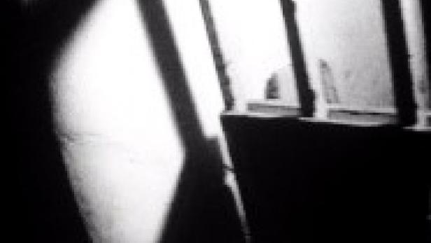 Das Innere eines Raumes mit einem Fenster und starken Licht- und Schattenkontrasten.